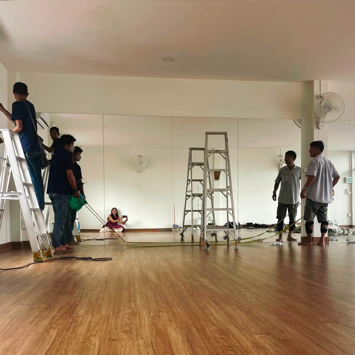 Installing the studio's mirrored wall