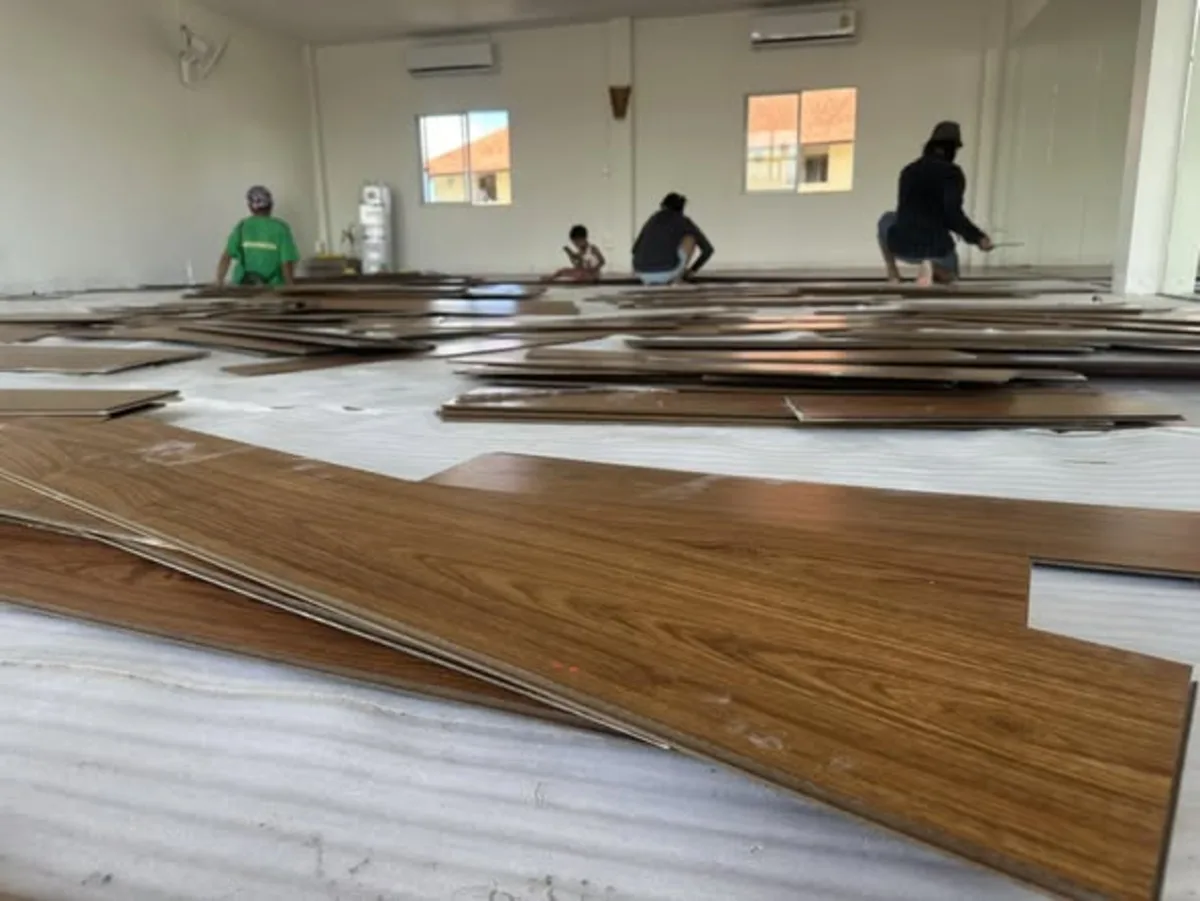 Floor installers laying new wooden planks