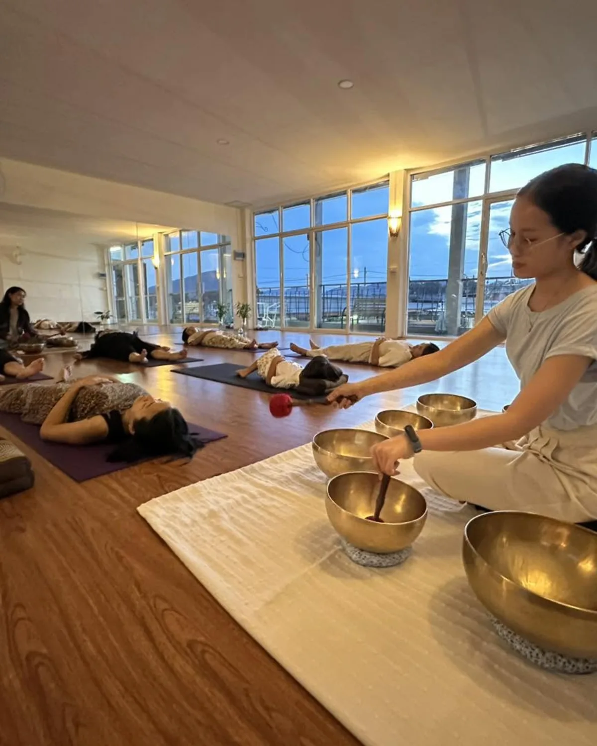 Facilitator playing Tibetan singing bowls during a sound bath