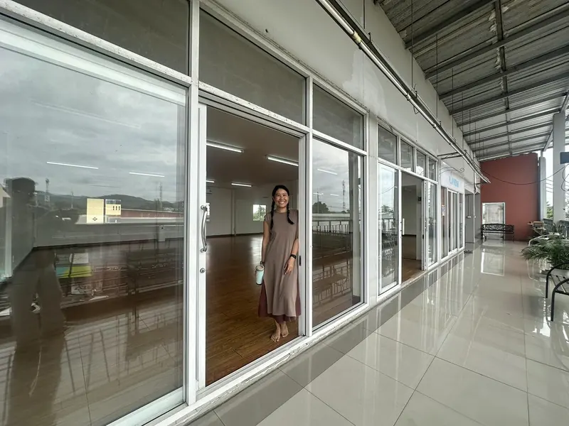 A smiling woman welcoming visitors at the open studio door